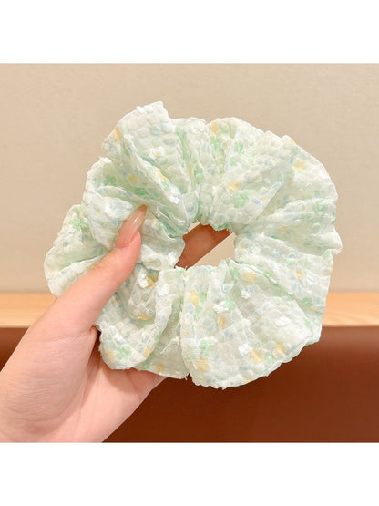Gifty floral scrunchie next to matching floral accessories