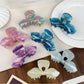 Beau iridescent bow-shaped hair claw clip on white background