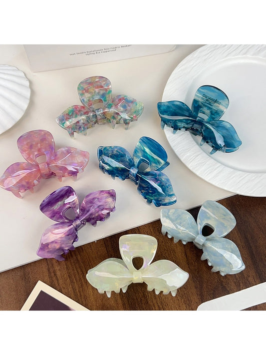 Beau iridescent bow-shaped hair claw clip on white background