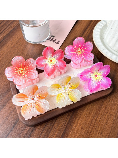 Close-up of Beau lifelike acetate floral claw clip with pink and white flower design