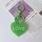 Purple heart-shaped pendant keychain displayed on a white background