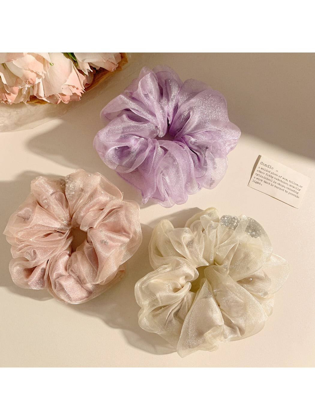 Solid color ruched scrunchie displayed on a wooden surface highlighting fabric texture