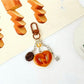 Mini baguette keychain showing detailed stitching on light brown leather
