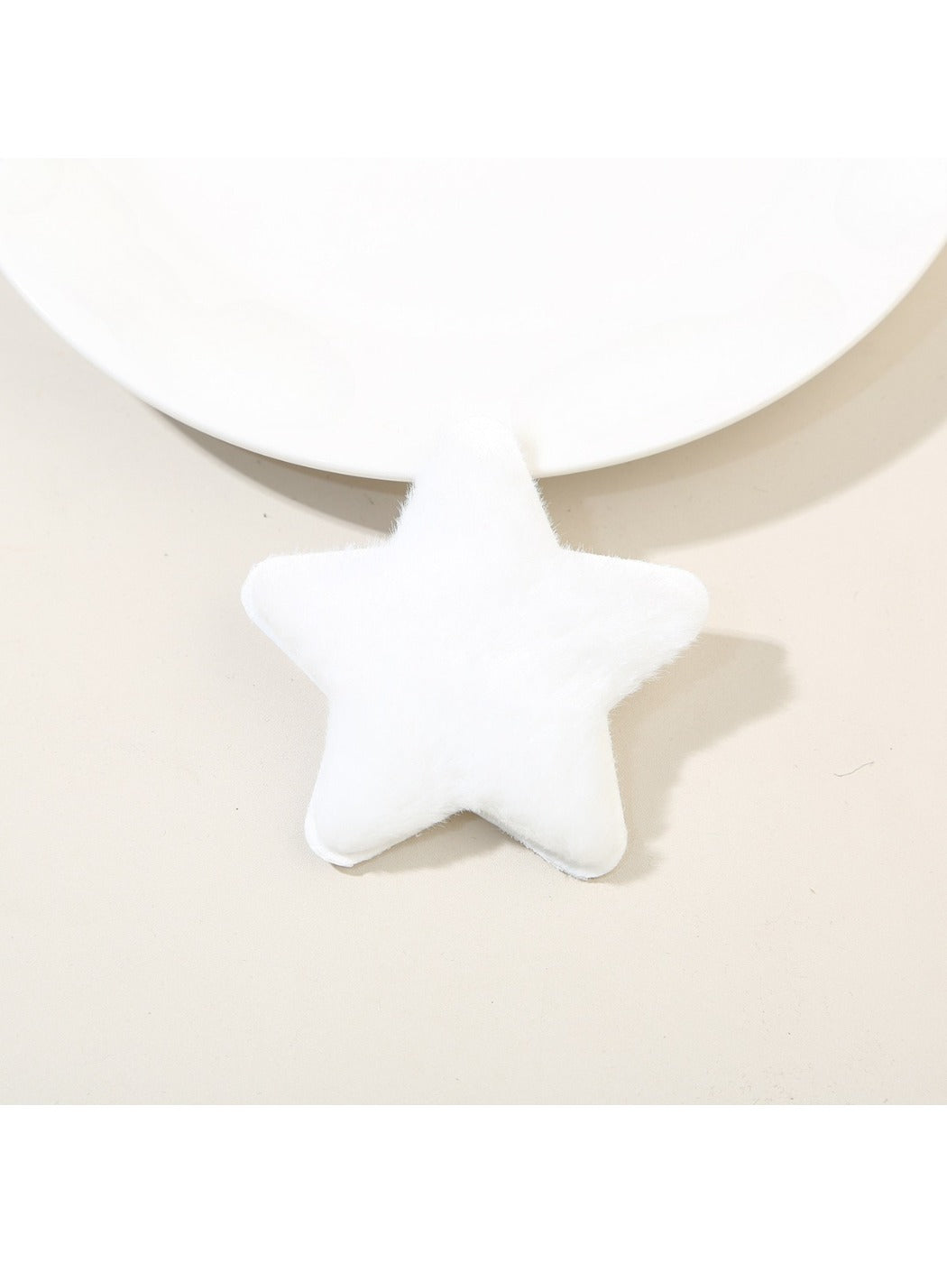 Beau star hair clip held between fingers showing size and plush material
