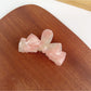 Beau classic bow shaped hair claw clip photographed on a neutral background