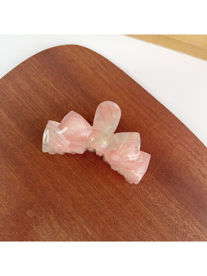 Beau classic bow shaped hair claw clip photographed on a neutral background