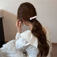 Side view of Gifty hair tie with pink bow worn on a wrist
