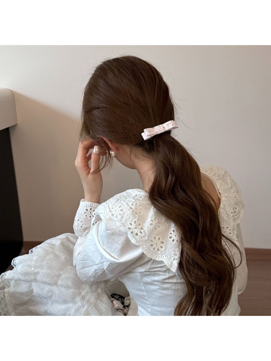 Side view of Gifty hair tie with pink bow worn on a wrist