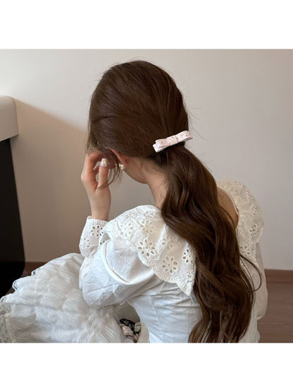 Side view of Gifty hair tie with pink bow worn on a wrist