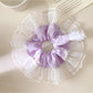 Close-up of Gifty plaid bow scrunchie showing fabric texture and pattern