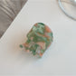 Beau hair clip placed on wooden surface emphasizing warm tortoiseshell colors