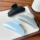 Beau hair clip held in hand displaying size and curved shape
