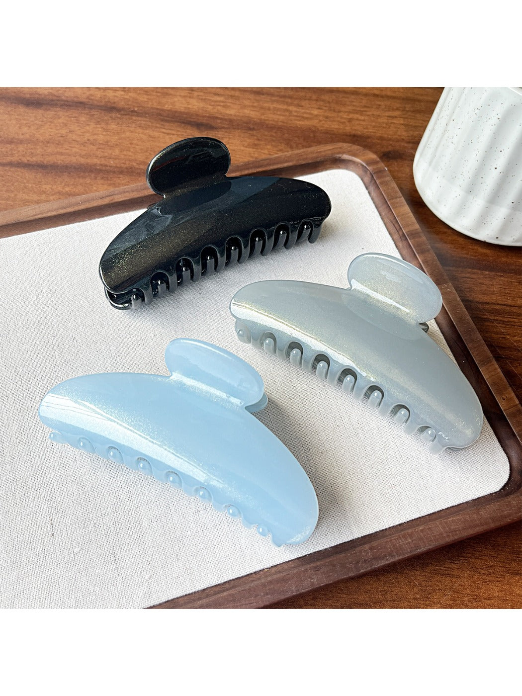 Beau hair clip held in hand displaying size and curved shape