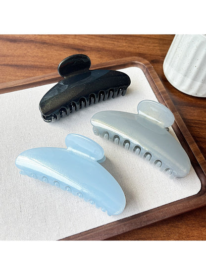 Beau hair clip held in hand displaying size and curved shape