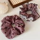 Polka dot ruffled scrunchie worn on a model's wrist with matching headband