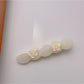 Top view of Beau rose decorated wavy hair clip showing full design