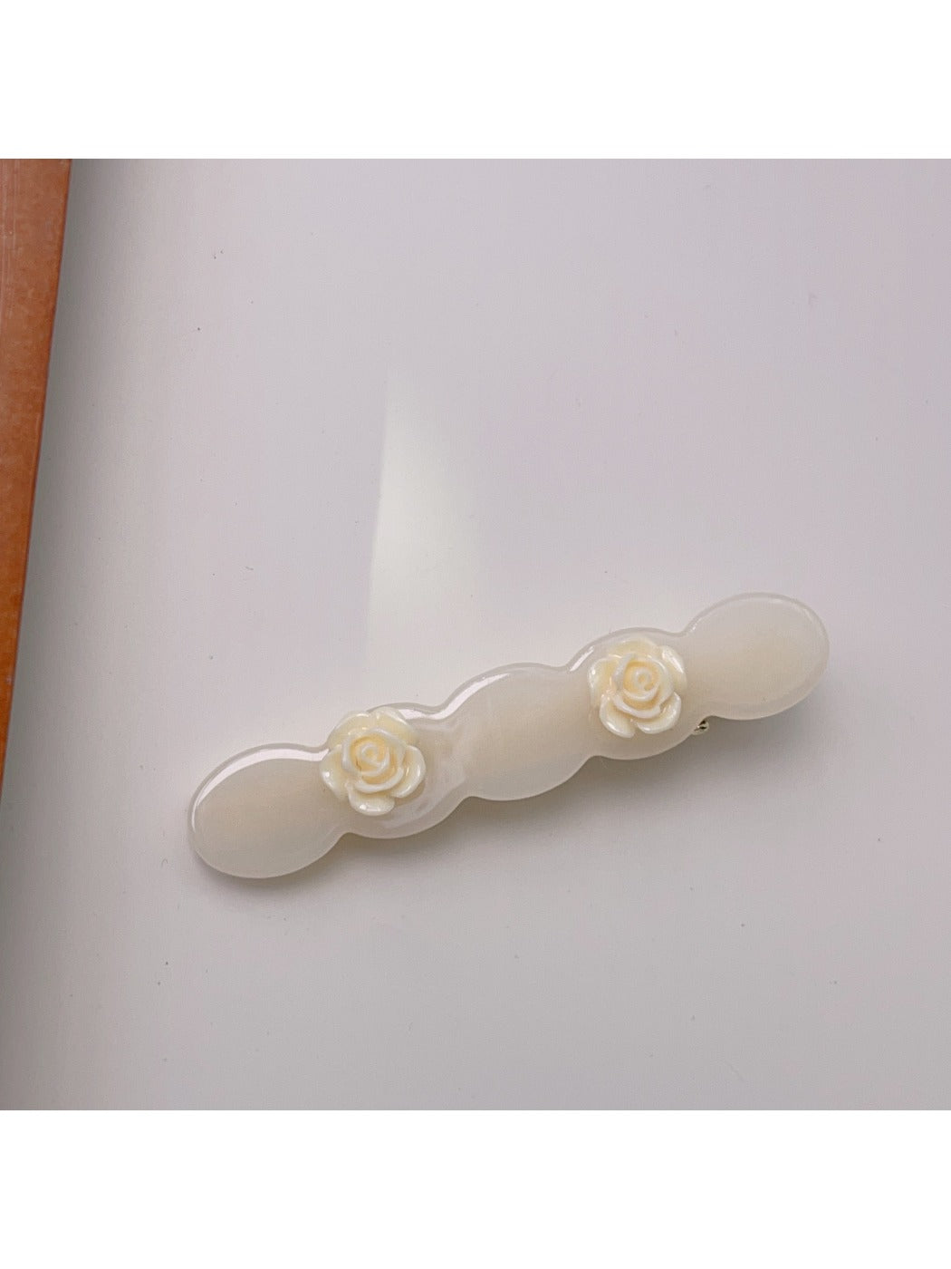 Top view of Beau rose decorated wavy hair clip showing full design