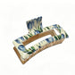 Beau hair clip worn in styled hair, showcasing its decorative flower pattern