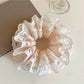 Gifty light pink scrunchie displayed on a wooden surface
