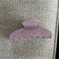 Beau pink polka dot claw clip photographed with a pastel background for styling
