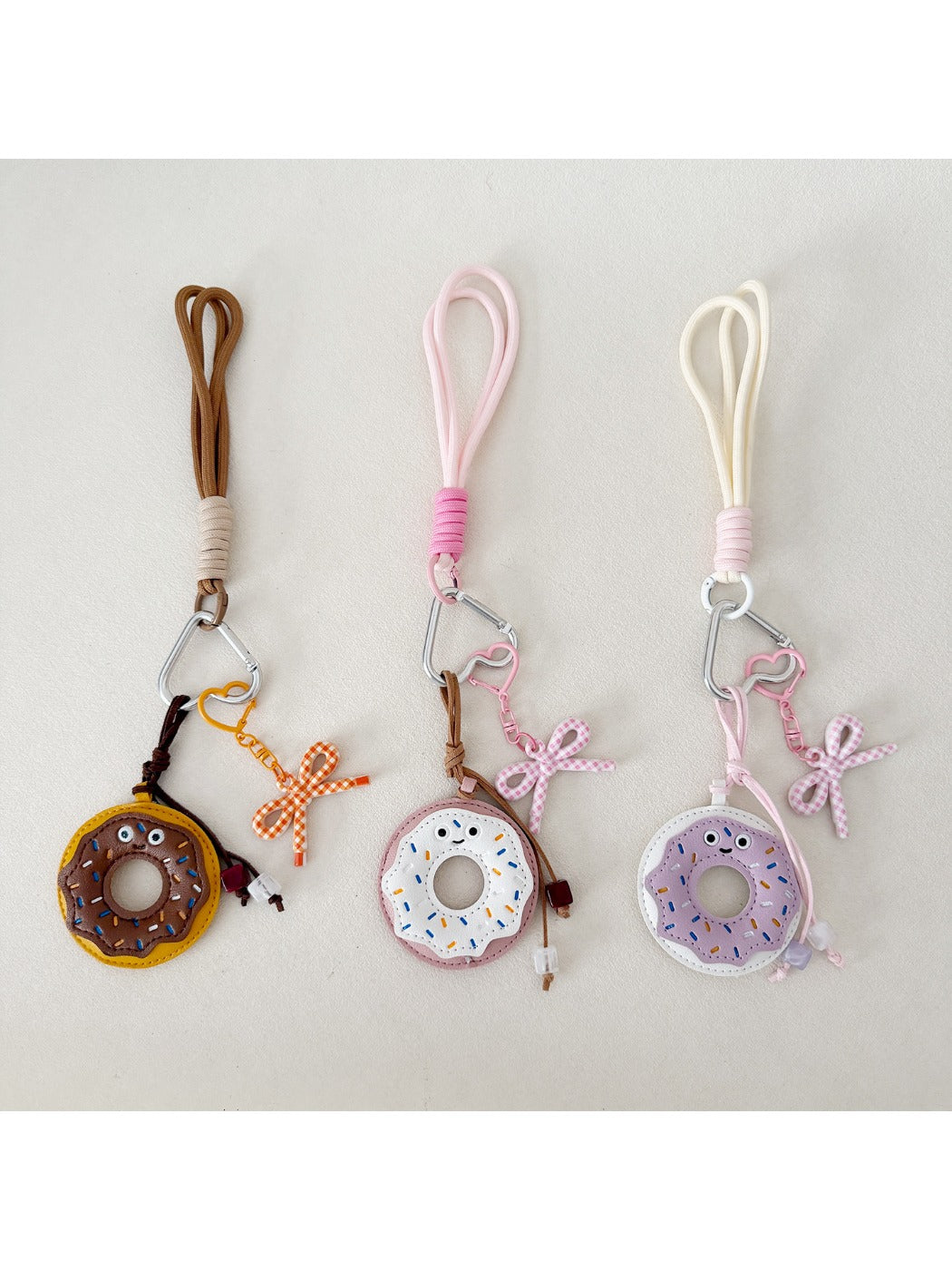 Pink donut keychain hanging from a set of keys on a wooden surface