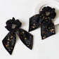 Model wearing Gifty printed bow hair tie styled in a ponytail