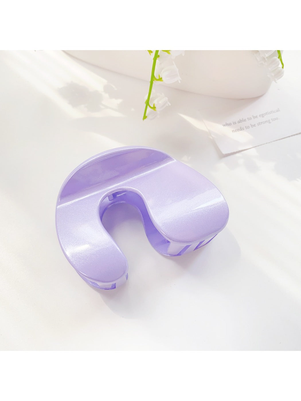 Beau hair claw clip placed on wooden surface with natural lighting