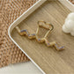 Beau wavy metal claw clip with shadow on white background