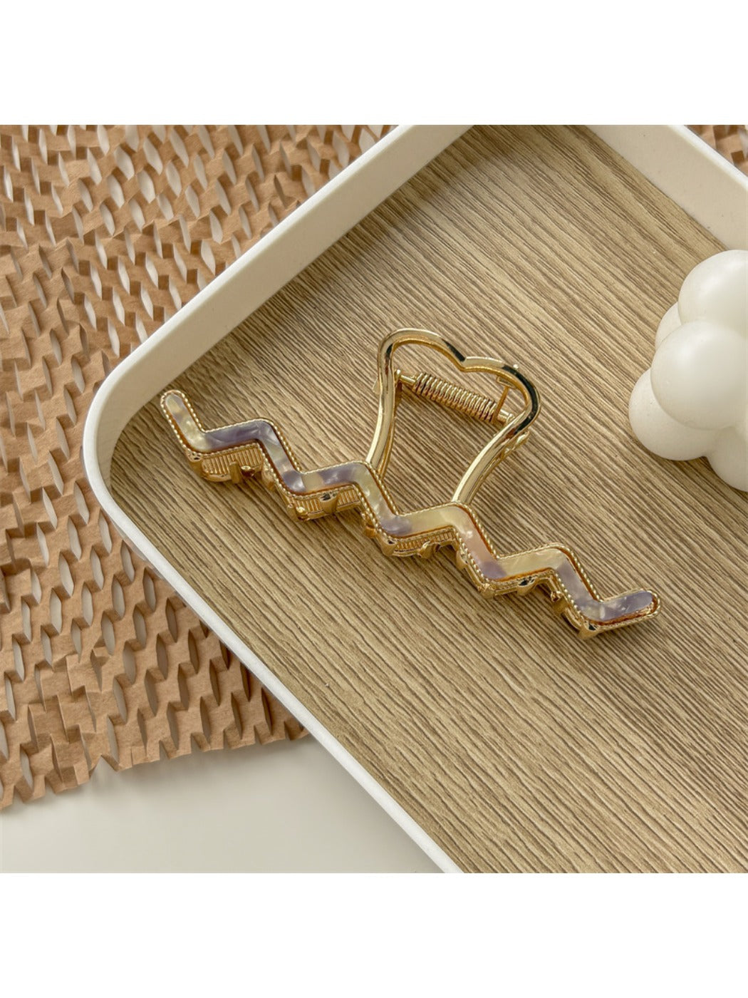 Beau wavy metal claw clip with shadow on white background