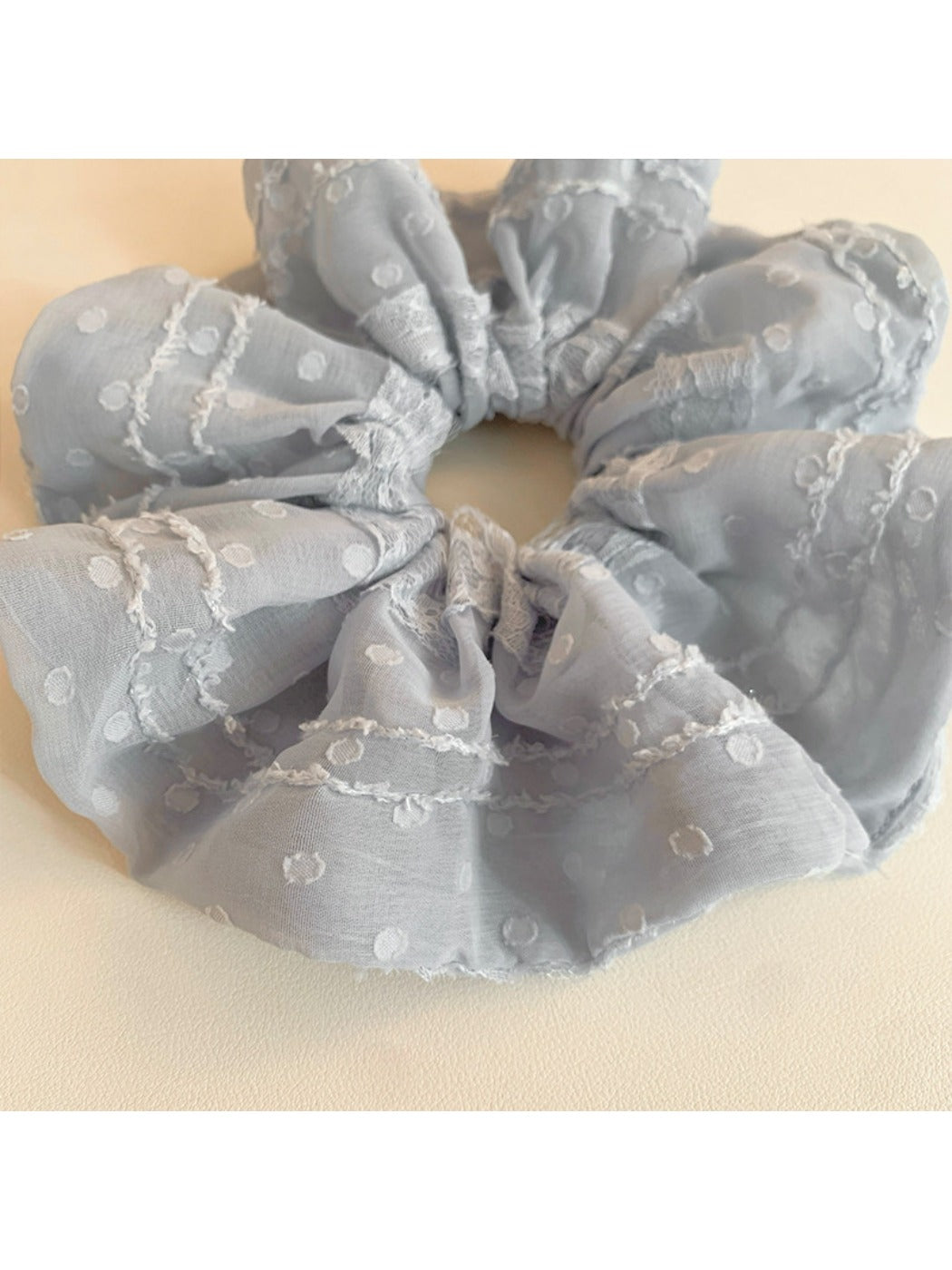 Close-up of Gifty ruffled scrunchie showing fabric texture and ruffle details