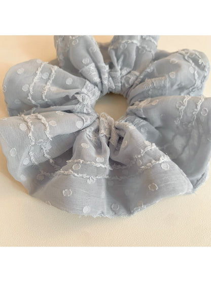 Close-up of Gifty ruffled scrunchie showing fabric texture and ruffle details