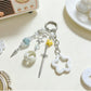 Close-up of delicate star charm on gold keychain with small ring attachment