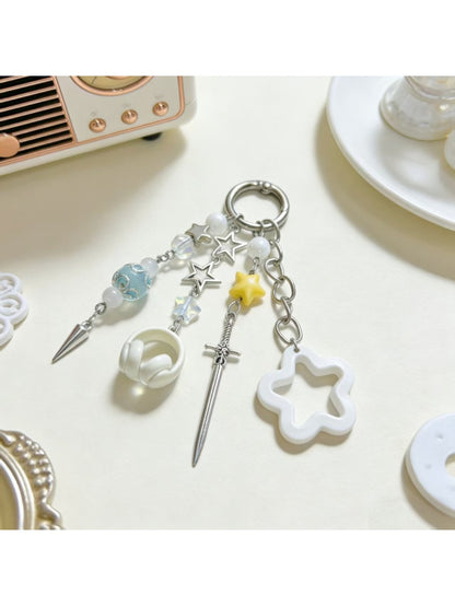 Close-up of delicate star charm on gold keychain with small ring attachment