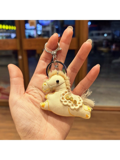 Keypus pony charm keychain displayed with other small accessories on a flat surface