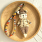 Keypus fabric doll keychain with smiling face and multicolor outfit on white background