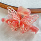 Beau hair claw clip styled in long hair with butterfly decoration visible