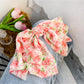 Red floral print bow scrunchie with elastic band visible