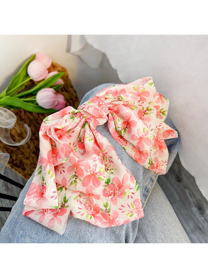 Red floral print bow scrunchie with elastic band visible