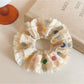Colorful polka dot scrunchie displayed flat showing ruched fabric detail