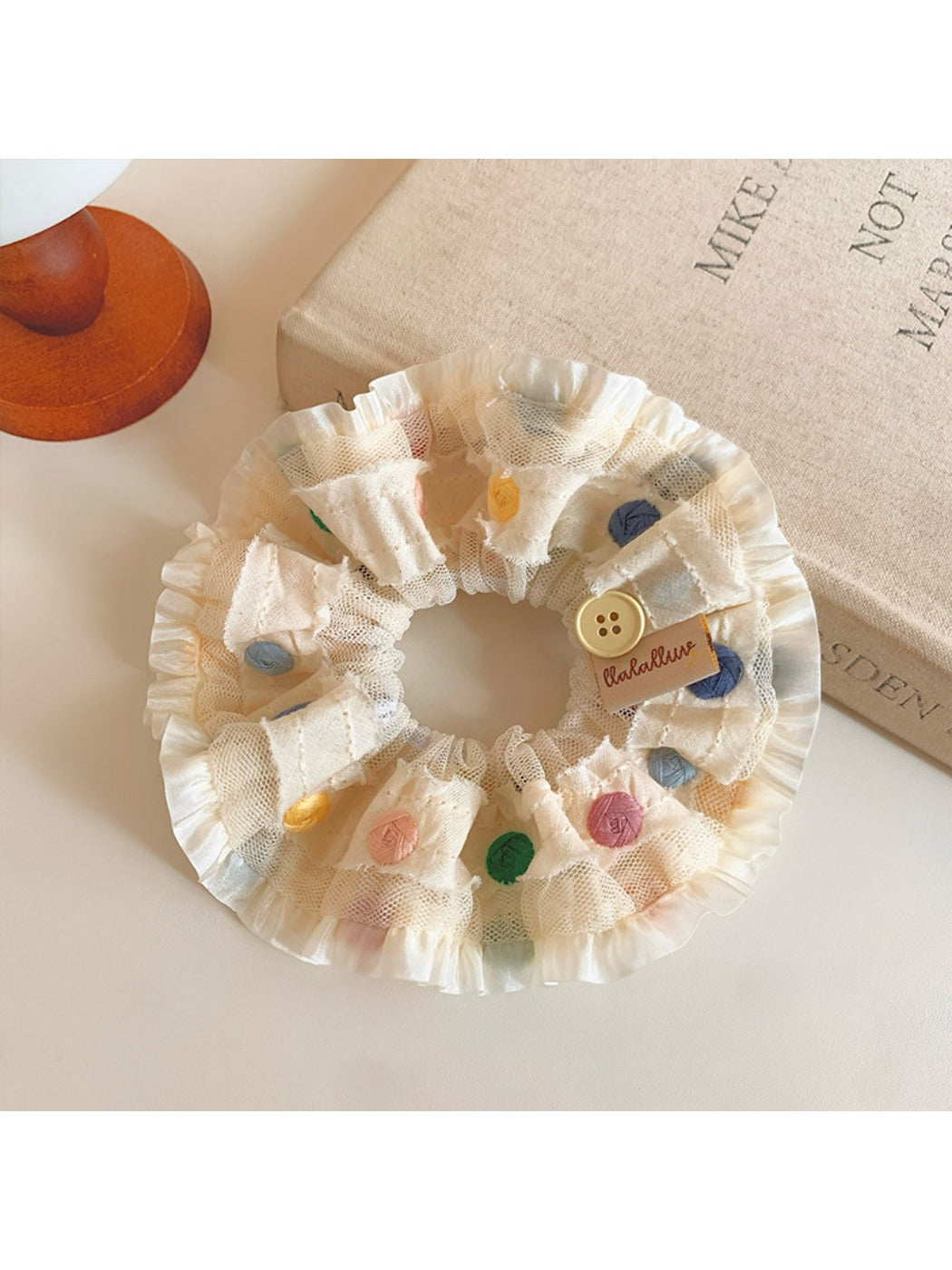 Colorful polka dot scrunchie displayed flat showing ruched fabric detail