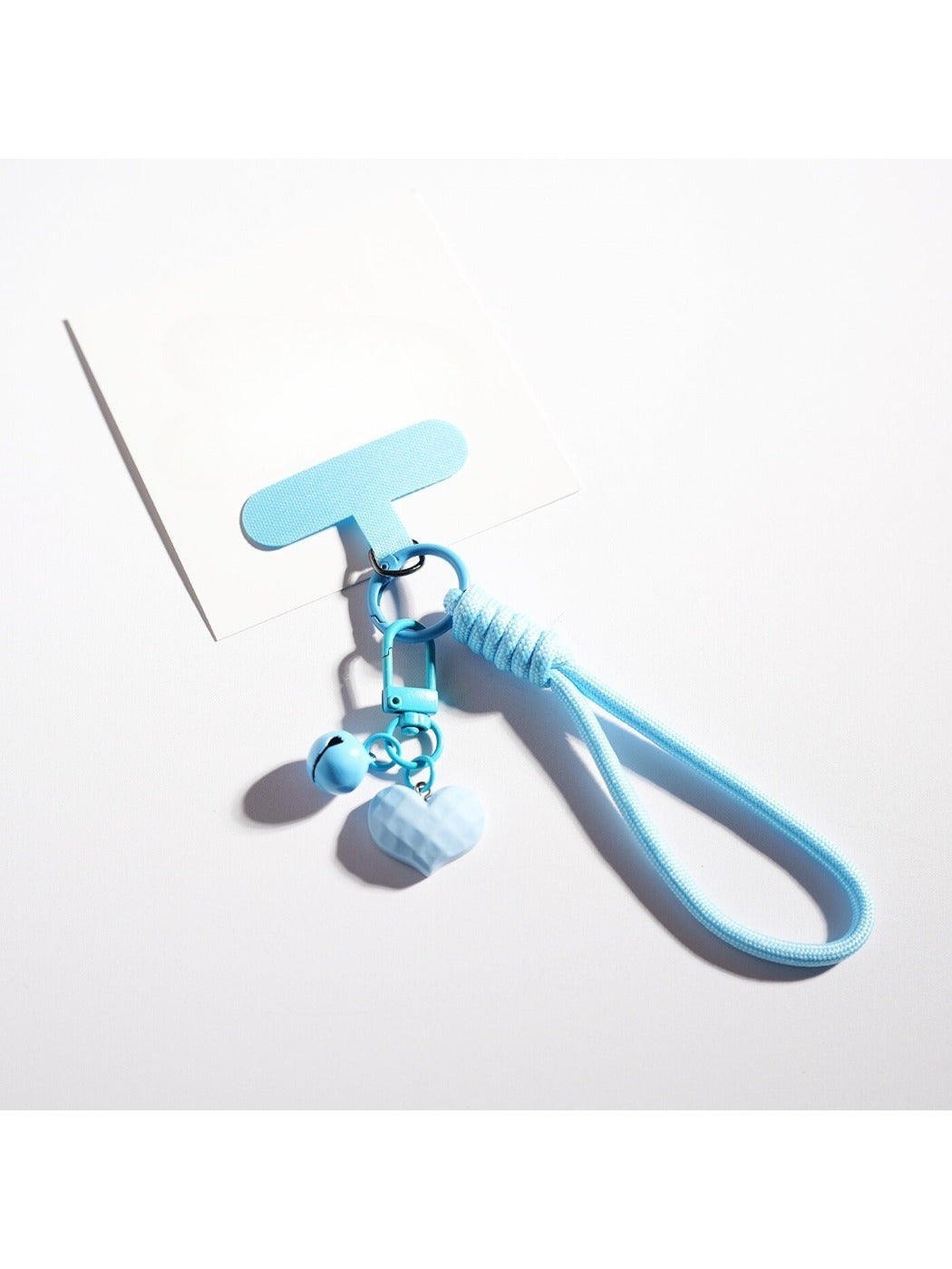 Heart-shaped keychain in pastel colors displayed on a light blue background