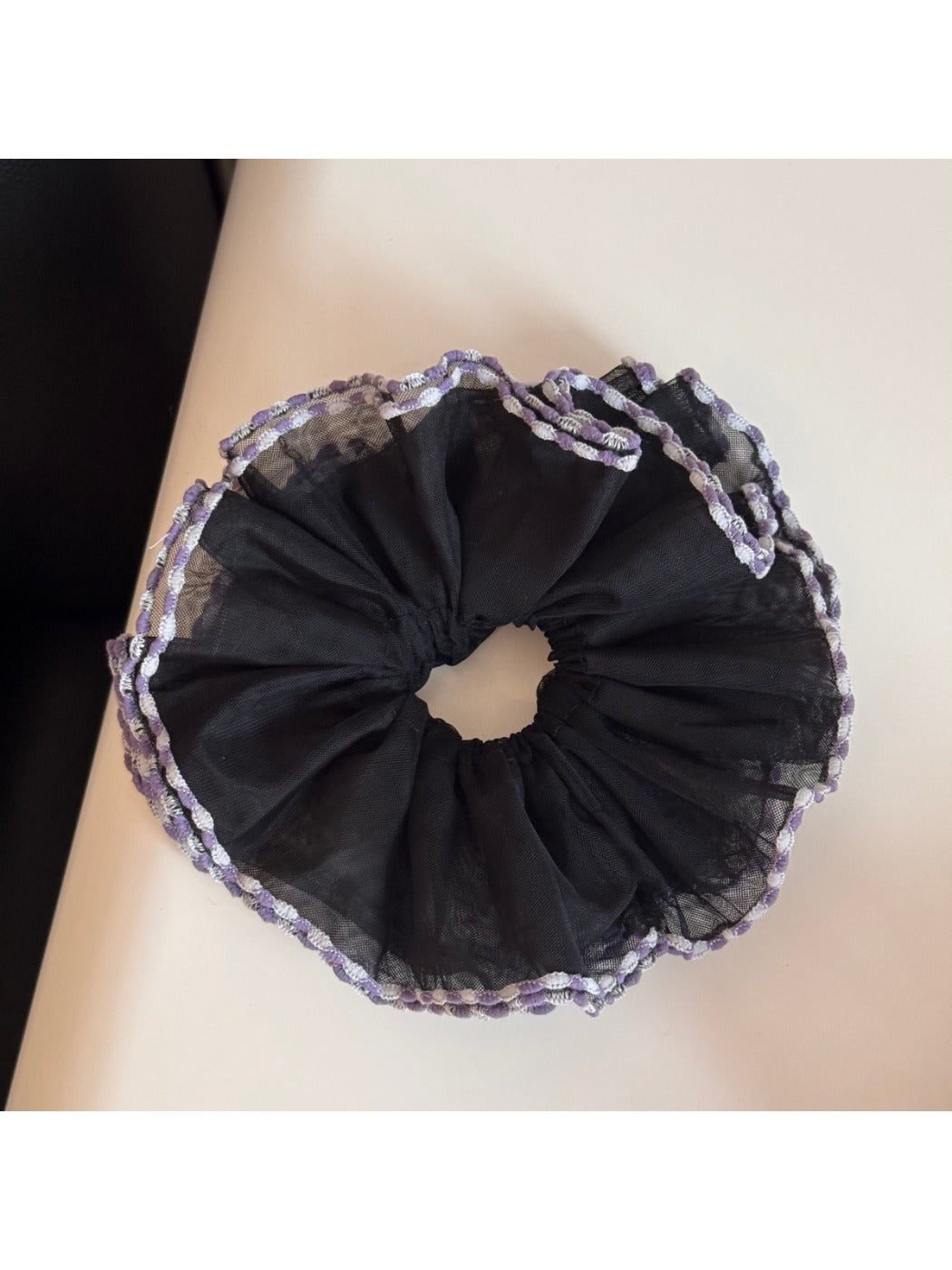 Gifty scrunchie held in hand demonstrating size and soft tulle material