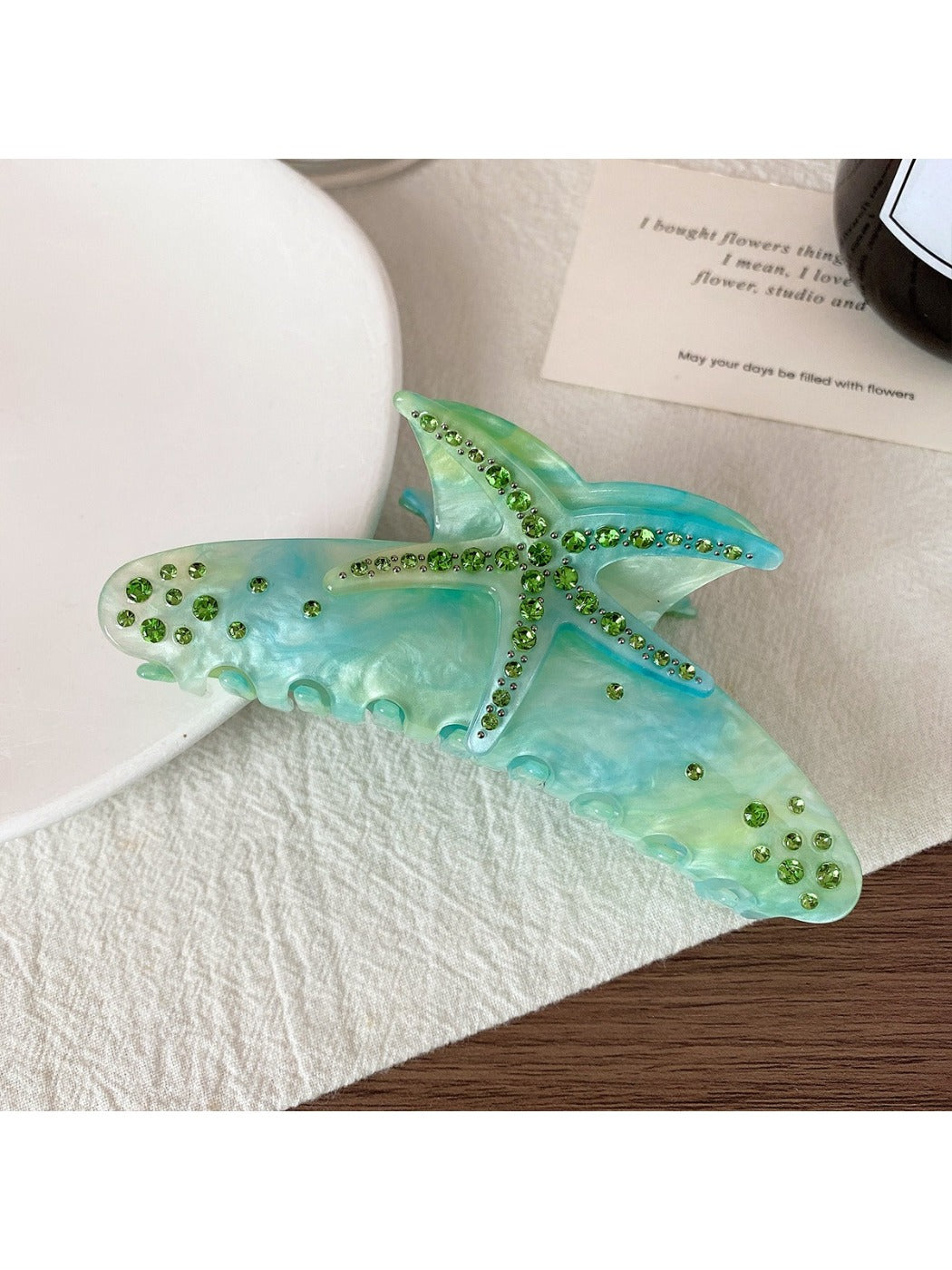 Colorful crescent hair claw clip displayed on a wooden surface with natural lighting