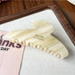 Beau claw clip resting on a wooden surface with soft natural lighting