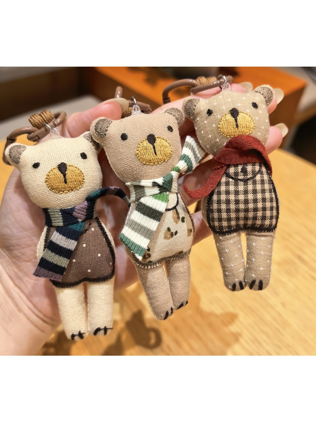 Close-up of fabric bear cub keychain showing stitched facial details