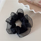 Glossy scrunchie folded to show its smooth, reflective surface
