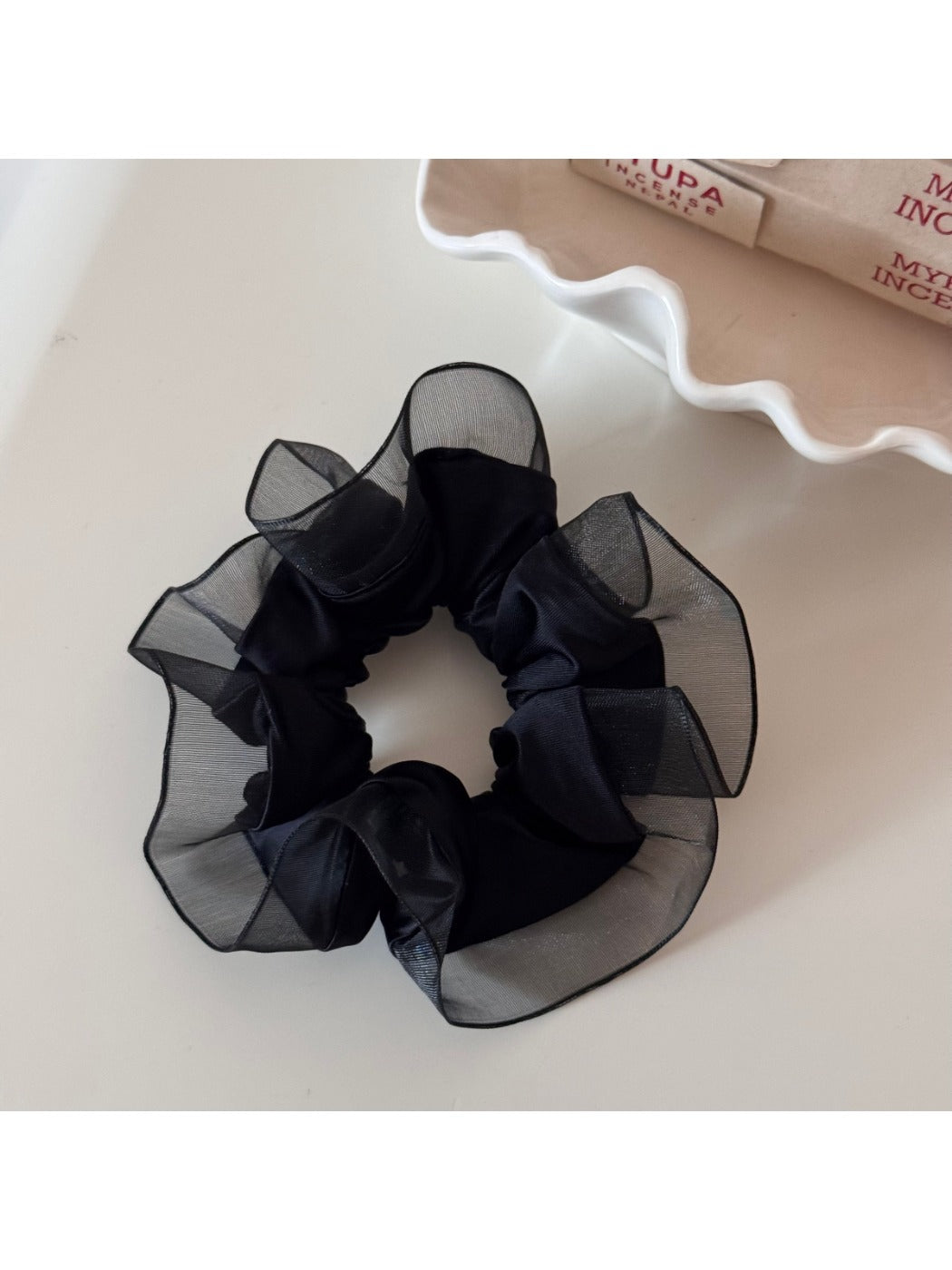 Glossy scrunchie folded to show its smooth, reflective surface