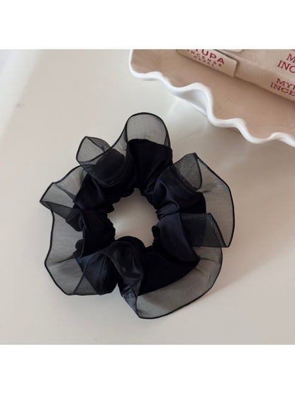 Glossy scrunchie folded to show its smooth, reflective surface
