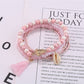 Model wearing multiple Lovra stackable tassel beaded bracelets on wrist