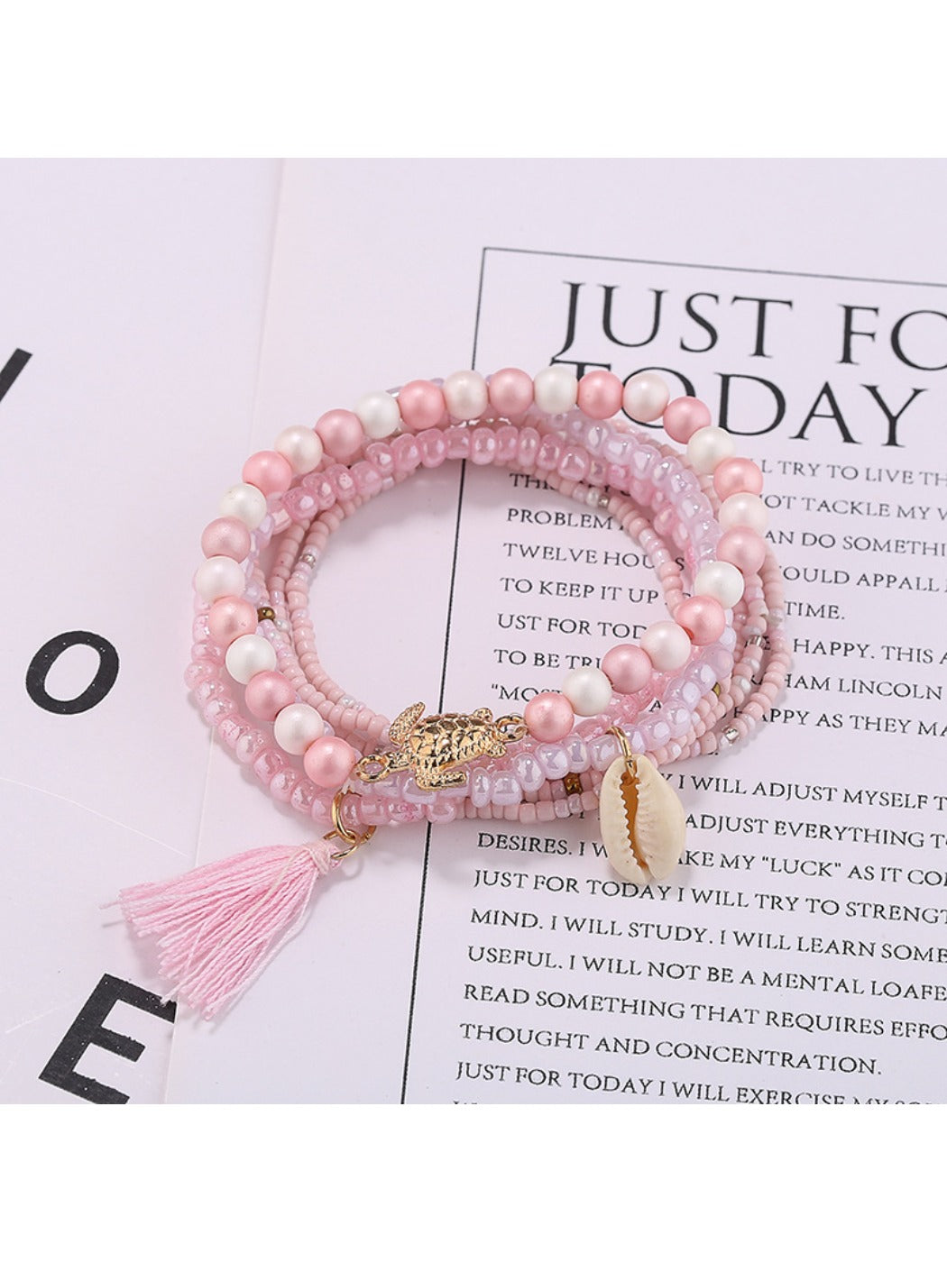 Model wearing multiple Lovra stackable tassel beaded bracelets on wrist